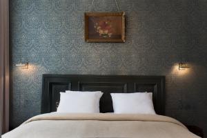 马斯特里赫特圣马丁雅各精品酒店的一张带两个枕头的床和一张墙上的照片
