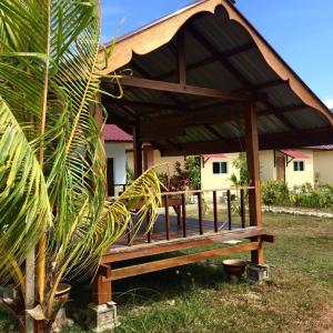 瓜埠Kawah Padi Garden Villa Langkawi的房屋前设有凉亭的木凳
