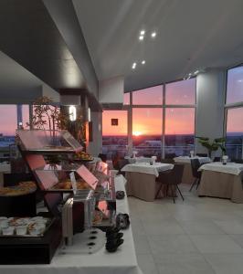 切里尼奥拉Grieco Business & Spa Hotel的一间提供自助餐和餐桌的餐厅