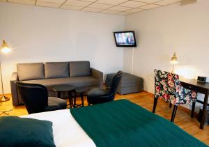 巴斯塔德拉斯塔哈兰德萨森的酒店客房配有一张床、一张沙发和一张书桌。