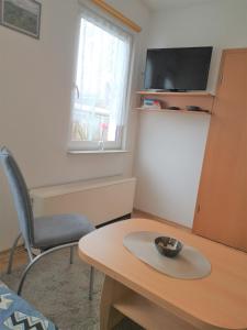 Usedom Town斯塔多赫恩公寓的配有桌子、椅子和电视的房间