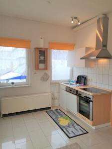 Usedom Town斯塔多赫恩公寓的厨房配有水槽和炉灶 顶部烤箱
