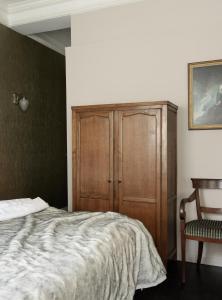 马斯特里赫特Boutique Hotel Grote Gracht的一间卧室配有一张床和一个木制橱柜