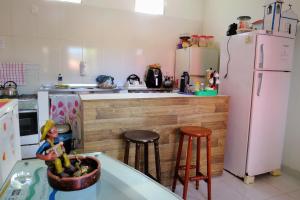 伊塔乌纳斯Tribo de Gaia的厨房配有白色冰箱和带凳子的台面