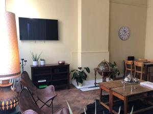 安特卫普安特卫普布莫朗旅舍的客厅配有电视和桌椅