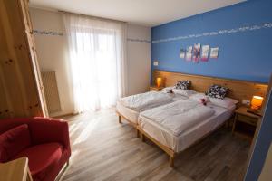 费德拉帕加内拉蒙大拿酒店的一间卧室设有两张床和蓝色的墙壁