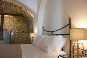 皮肖塔Santo Mercurio Country House的一间卧室设有一张床和石墙