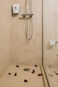 波尔图圣约斯酒店的楼下的浴室设有淋浴,部分花瓣位于地板上