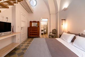 GuagnanoCorte dei Furesi的一间卧室配有一张床和一张书桌及电视