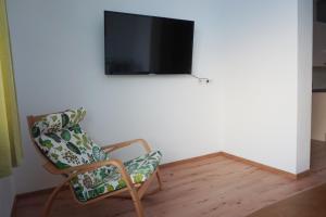 FerschnitzLandhaus Schaidreith的客厅配有椅子和平面电视