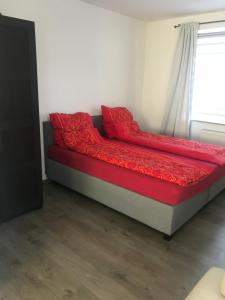 多特蒙德Wohnung am Phönixsee的红色床单和窗户的客房内的一张床位