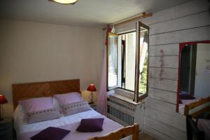古雷特冰川酒店的一间卧室配有一张带紫色枕头的床和窗户。