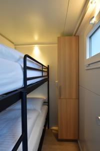 马斯特里赫特Cosy floating boatlodge, "Paris"的一间卧室设有两张双层床和一扇窗户。