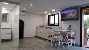 卡内·德·玛尔Casita en plena naturaleza con piscina y wifi gratis的厨房配有桌子,墙上配有电视。