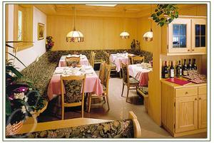 奥蒂塞伊苏雷格伊思酒店的用餐室配有桌椅和瓶装葡萄酒