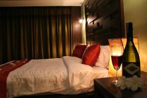 拉迈Lamoon Lamai Residence & Guesthouse的酒店客房,配有一张床和一瓶葡萄酒
