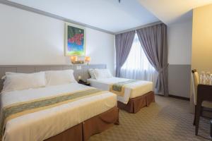 马六甲霍尔马克休闲酒店的酒店客房设有两张床和窗户。