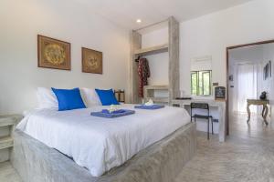 涛岛Aloe Villa的一间卧室配有一张大床,上面有两道蓝色的菜肴