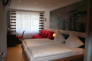 因河畔辛巴赫德威马维斯布劳旅馆的卧室配有白色的床和红色椅子
