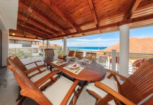 阿利卡纳斯Villa Eleni的阳台的用餐室配有桌椅