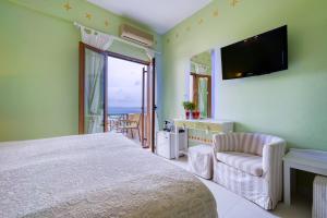 圣加利尼Rozmari and Spa的一间卧室配有一张床、一台电视和一把椅子