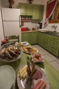 梅加克瑞奥Το Ηλιοβασίλεμα的厨房配有绿色橱柜和餐桌上的盘子