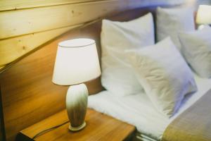 苏兹达尔苏维特利特伦酒店的一张桌子上的一盏灯,床边有枕头