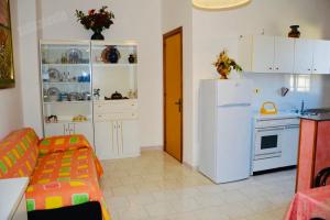 丽都玛里尼Casa Vacanza BERMUDA的厨房配有白色冰箱和炉灶。