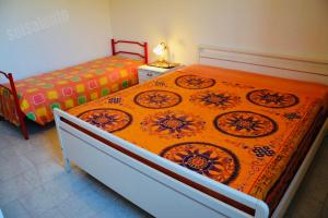 丽都玛里尼Casa Vacanza BERMUDA的一间卧室配有一张带橙色毯子的大床