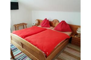 巴德加斯坦Pension Charlotte的一间卧室配有一张铺有红色床单的木床。