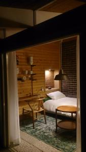 多治见市多治见旅馆的一间卧室配有一张床、一张桌子和一张桌子。