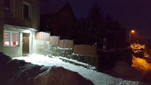 杜什尼基-兹德鲁伊Apartament Grosik的夜晚有雪覆盖的房子