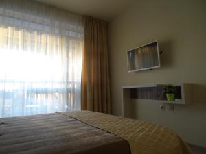 希萨里亚Апартамент 13的一间卧室设有一张床和一个带电视的窗户。