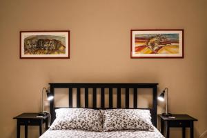 卡利亚里Su Murdegu的卧室配有两张墙上的照片和一张床