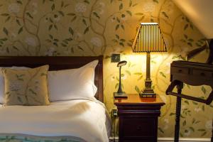 温彻斯特奥尔德瓦因酒店的一间卧室配有一张床和一张带台灯的桌子