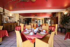 喀斯和迭日Hôtel Restaurant Le Mûrier de Viels - Figeac Grand的一间带红色桌布的餐桌的用餐室