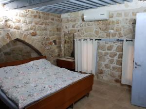 阿卡恩萨尔科里托管宾馆的一间卧室设有一张床和石墙