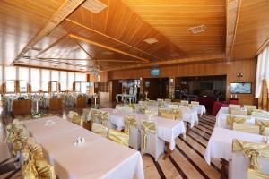 安塔利亚奥尔比亚酒店的宴会厅配有白色的桌子和黄色的椅子