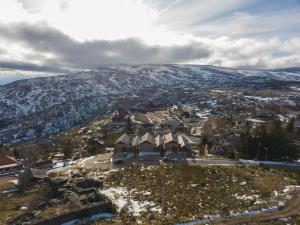 佩尼亚什达绍迪Estrela da Serra - Alojamento Local的享有一个雪覆盖的山的小镇的空中景色