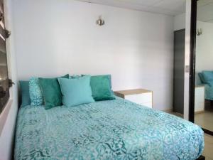 圣胡安Urban Terrace Apartment in San Juan的一间卧室配有蓝色的床和蓝色枕头