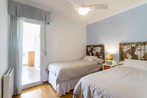 阿利坎特Villamar - Relax, Sol y Playa的白色的客房设有两张床和窗户。