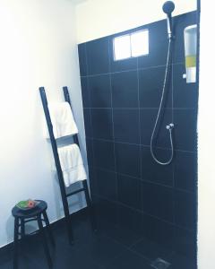 高兰Papillon Bungalows的带淋浴的浴室(带蓝色瓷砖墙)
