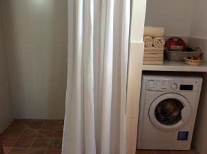 卡拉索纳CAN TONI DEN MESTRE的洗衣机旁的白色淋浴帘