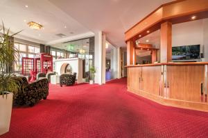 Hinte诺沃姆酒店的大堂铺有红地毯,墙上配有电视