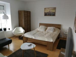 米什科尔茨Ida Apartman的一间小卧室,配有一张床和一把椅子
