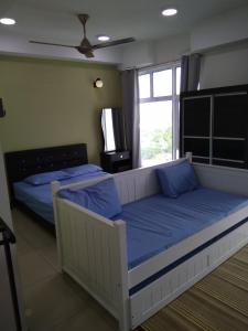 哥打巴鲁佩尔达纳2号公寓的一间卧室配有两张带蓝色枕头的床和窗户。