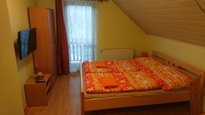 SúľovApartmány Súľov 183的一间卧室配有一张带橙色毯子和窗户的床。