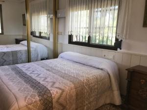 Godella"La Chacra" Casa Típica Valenciana的一间卧室设有两张床和两个窗户。