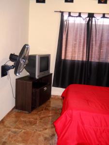 马拉圭Style Malargue a 100 mtrs del centro,ubicadisimo的一间卧室配有一张床、风扇和电视。
