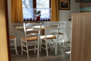 莫斯特拉纳Apartma Lipa的厨房配有桌子和四把白色椅子